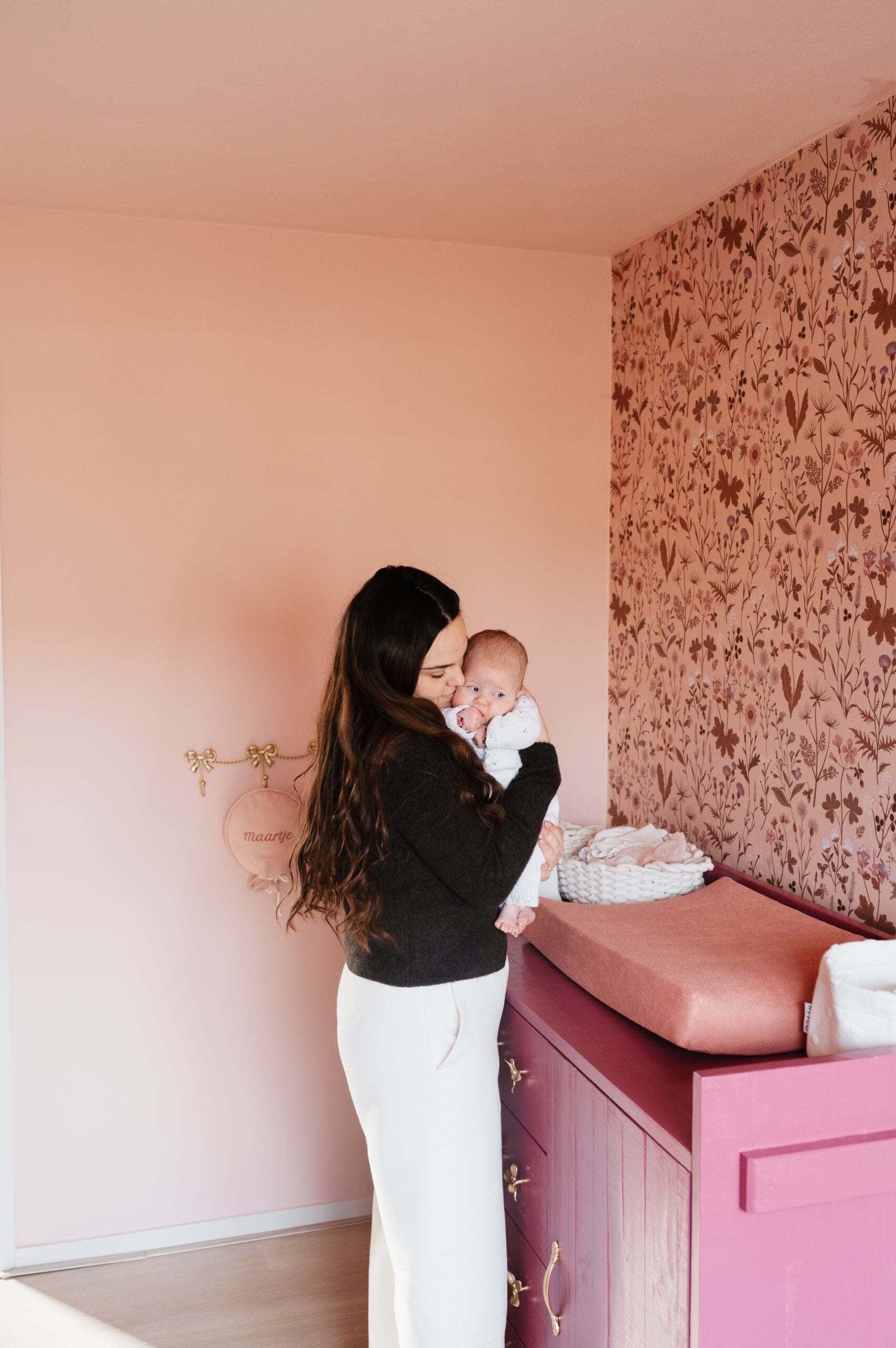 Moeder met baby in roze babykamer – Studio Roos Fotografie