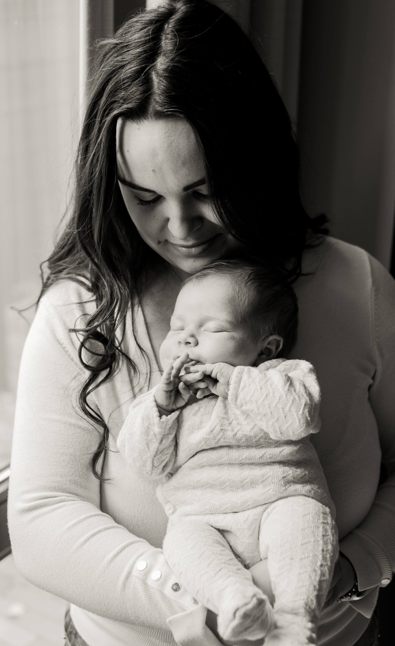 Moeder wiegt haar slapende newborn, zwart-wit – Studio Roos Fotografie