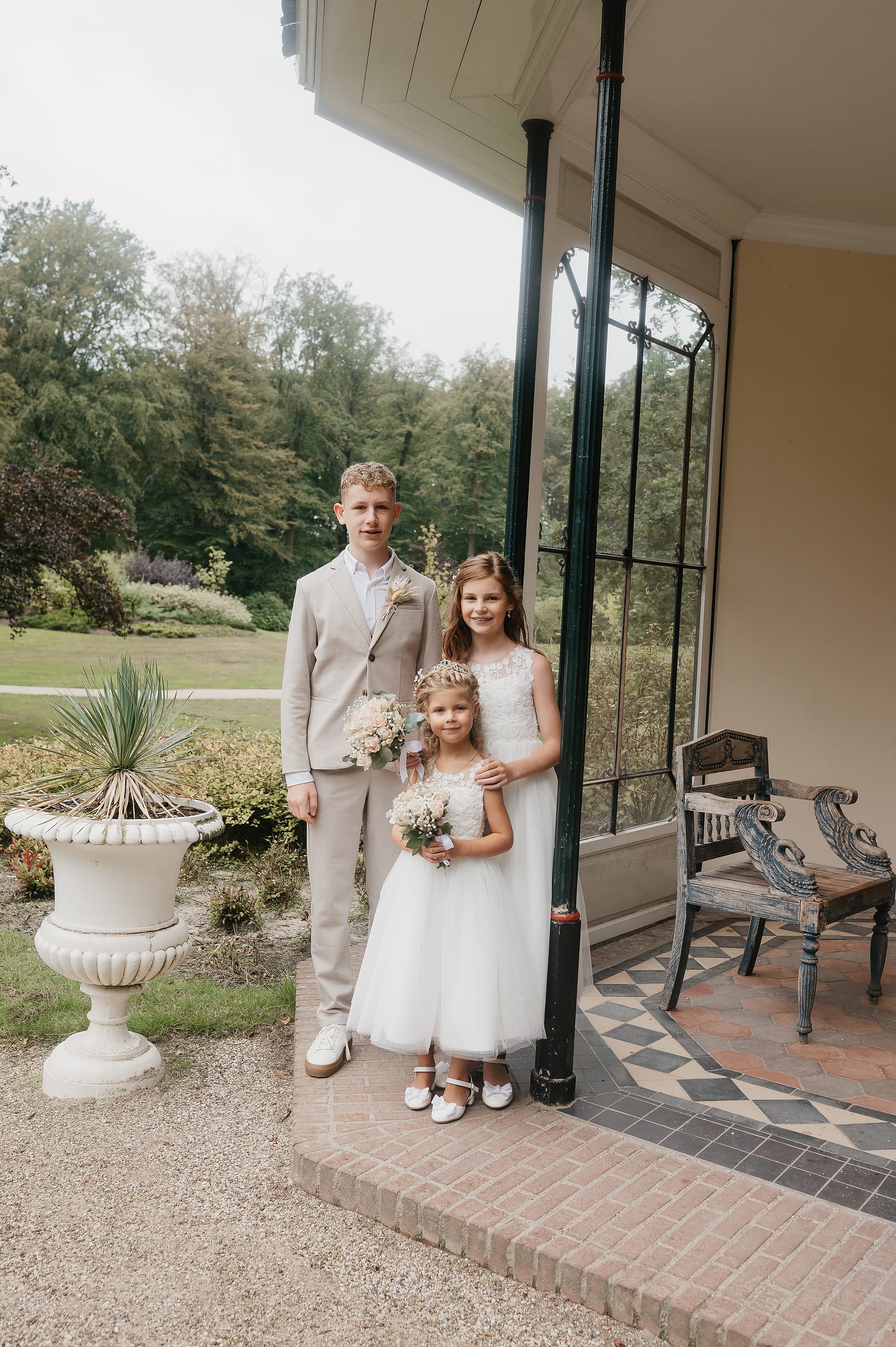 Kinderen in bruiloftskleding op de veranda van het landhuis – Studio Roos Fotografie