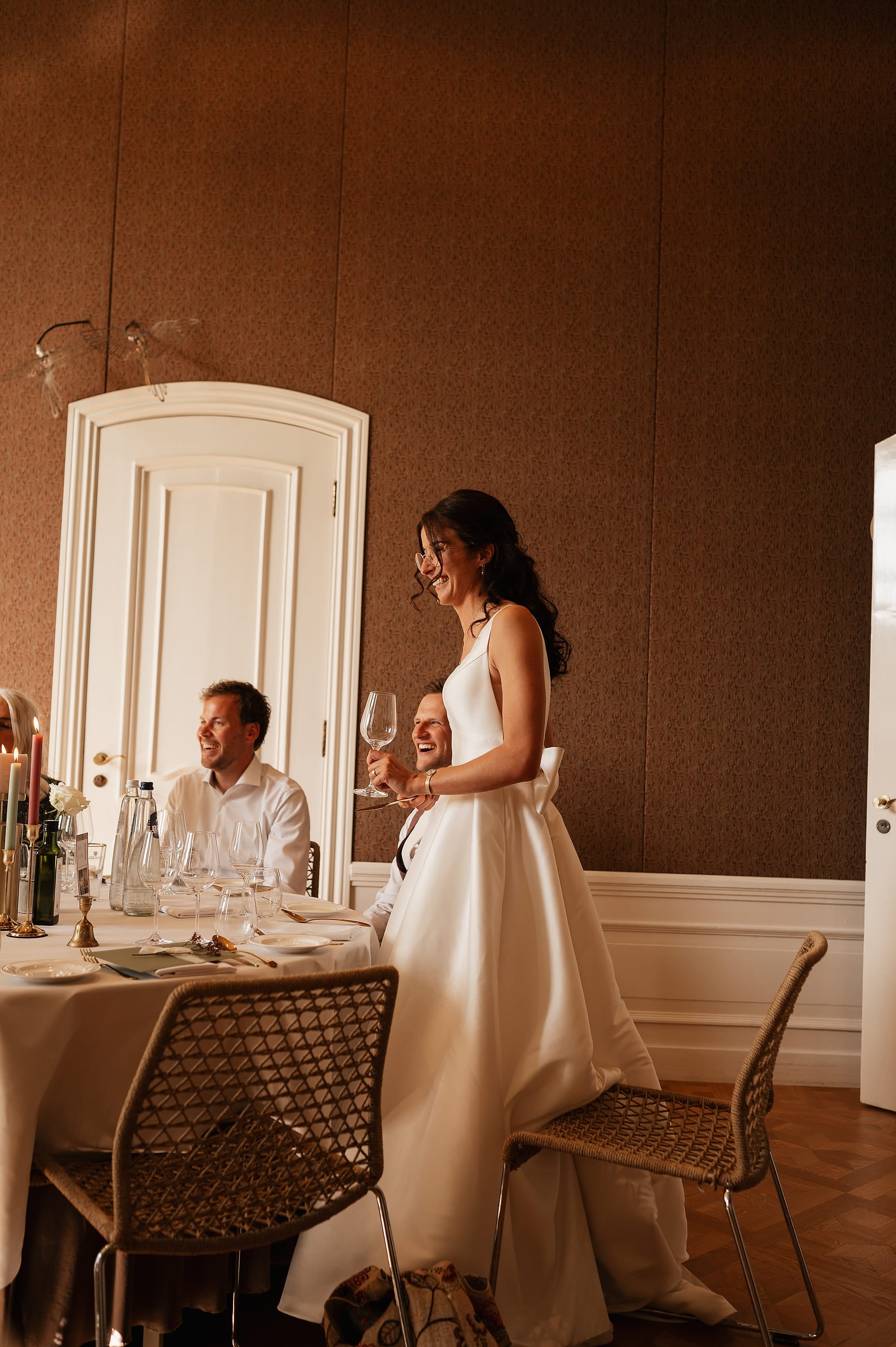 Bruid lacht tijdens het diner in de eetzaal – Studio Roos Fotografie